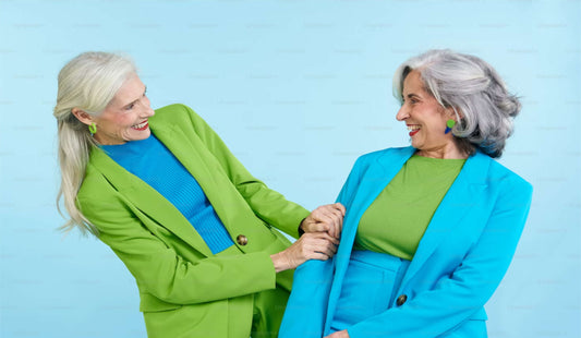 Image of two women one in the green jacket one in the blue jacket both facing one another with big smiles